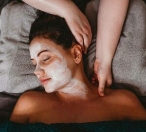 A woman getting a facial mask and massage at a spa